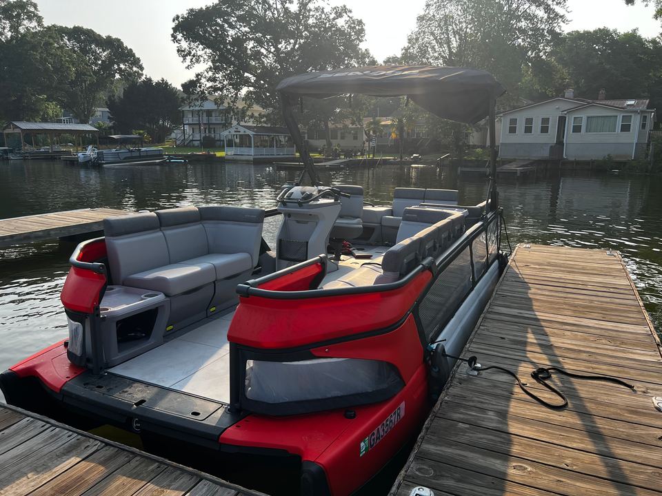 Gray lounge seating and open deck of the red Sea-Doo Switch, tied up at the dock