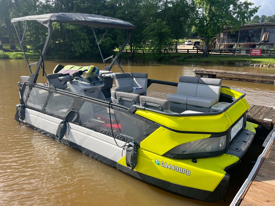 Yellow Sea-Doo Switch Cruise tritoon tied up at a wooden dock with its bimini top up