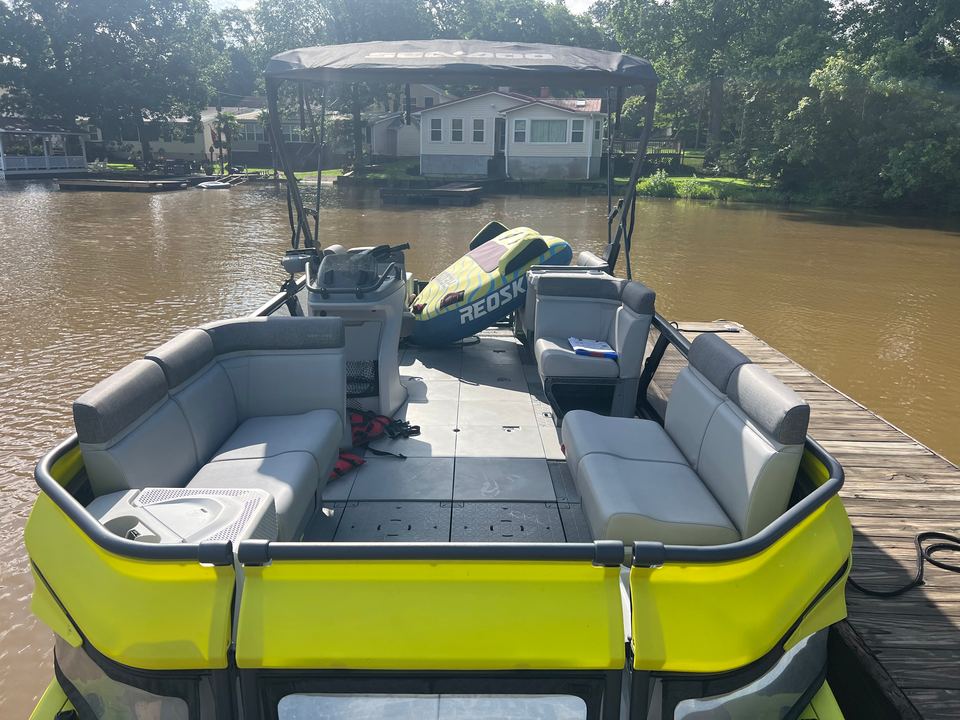 Rear lounge seats of the yellow Sea-Doo Switch, with a towable tube on the deck